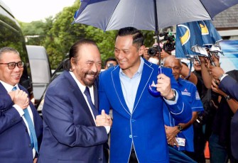 Ketua Umum NasDem, Surya Paloh saat disambut hangat dan dipayungi langsung oleh Ketua Umum Partai Demokrat, Agus Harimurti Yudhoyono (AHY) di depan kantor DPP Partai Demokrat, Rabu (22/2).
