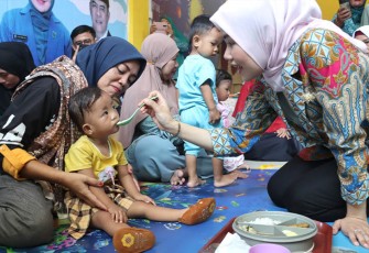 Hafizha menyuapi Rantang Sehat (aneka makanan penuh gizi) kepada anak-anak Balita dan Baduta