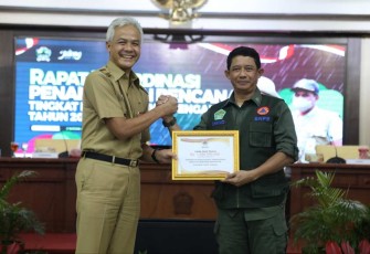 Kepala BNPB Letjen TNI Suharyanto (kanan) secara simbolis menyerahkan bantuan Dana Siap Pakai (DSP) dengan total 4,25M yang diterima langsung oleh Gubernur Jawa Tengah Ganjar Pranowo (kiri) untuk bantuan operasional penanganan darurat banjir, Senin (2/1).