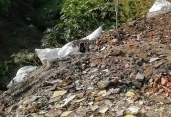 Penimbunan sampah bekas material bangunan di bantaran kali Curah Banteng