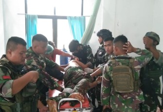 Satgas Yonif 133/Yudha Sakti saat memberi pertolongan ke salah satu prajurit terluka.