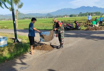 Sertu Zaenal Bersama Warga Membersihkan Saluran Air
