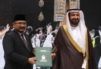 Menag Yaqut terima dokumen MoU terkait kuota jemaah haji dari Menteri Haji Saudi Tawfiq, dengan latar belakang foto Kabah di sela Pameran Haji