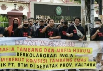 Aksi membentangkan spanduk di depan PN Surabaya, Minggu (14/5)