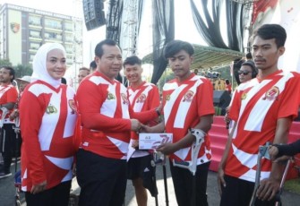 Kapolda Jatim Irjen Pol Toni Harmanto saat memberikan hadiah warga disabilitas binaan polisi RW Polda Jatim di Surabaya, Minggu (2/7)