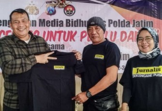 Kabid Humas Polda Jatim Kombes Dirmanto saat memberikan baju saat sarasehan media bersama jurnalis di Kota Batu, Minggu (3/9)
