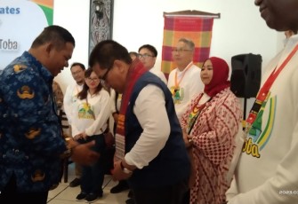 Asisten II Pemkab Samosir Hotraja Sitanggang memberikan Syal Ulos kepada delegasi