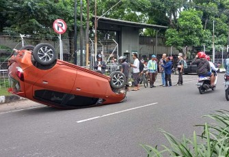 Daihatsu Ayla AD 1466 IP terguling setelah menghantam pembatas jalan akibat tertabrak dari belakang oleh Toyota Corrola AD 7729 DF, di depan PT Gunung Subur, Jaten, Karanganyar, Kamis (13/4/2023).