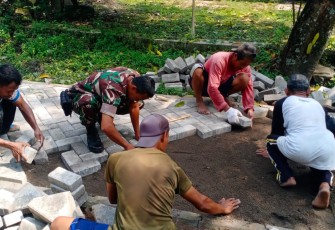 Babinsa Bantu Warga Pasang Paving Jalan Desa