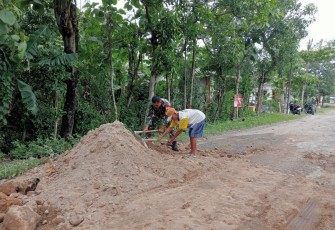 Babinsa Koramil Balerejo Bantu Warga Perbaiki Jalan Berlubang