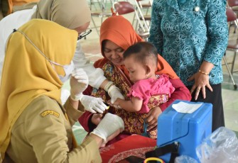Seorang balita sedang mendapatkan imunisasi polio dari petugas kesehatan Dinkes Karanganyar.