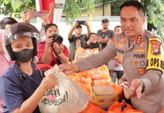 Kapolres Metro Jakarta Barat Kombes Pol M Syahduddi saat melayani warga membeli paket sembako murah di Mapolres, Rabu (28/2)