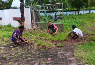Sertu Tangkas Ajak Warga Kerja Bakti Bersihkan Taman di Pinggir Jalan Poros 