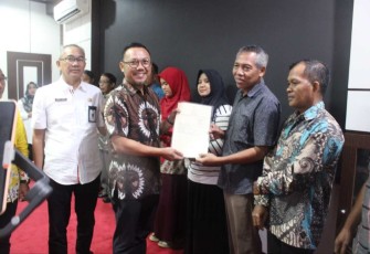 Kakan BPN Palangkaraya Indra Gunawan saat menyerahkan sertifikat elektronik ke warga masyarakat, Rabu (18/12)