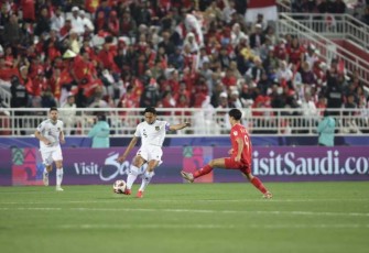 Rizky Ridho saat menghalau bola hendak direbut pemain Vietnam 