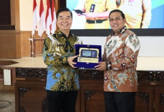 Dirjen Dukcapil Teguh Setyabudi memberikan cenderamata 