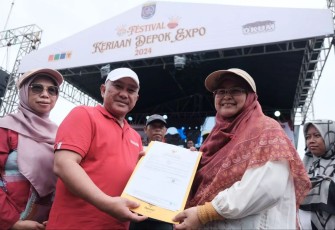 Wali Kota Depok, Mohammad Idris didampingi istrinya menyerahkan sertifikat kepada pendamping WUB dalam acara Depok Expo 2024, di Alun-alun Timur, GDC, Minggu (08/12/24)