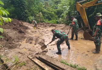 Anggota Koramil 1310-05Kauditan Kodim 1310Bitung saat melakukan pembersihan badan jalan Marawas yang di akibatkan tanah longsor