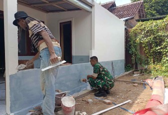 Bantu mengecat rumah warga desa binaan