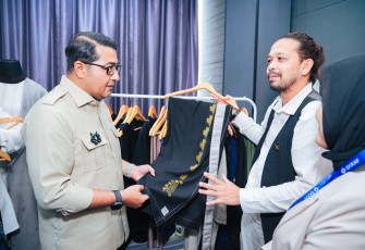 Menteri Ekonomi Kreatif, Teuku Riefky Harsya, meninjau produk fesyen pada acara Bootcamp II Akselerasi Fesyen Muslim Indonesia, Aceh, Selasa (25/11/2025).