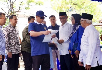 Menteri Nusron saat menyerahkan sertifikat HGB di kampung nelayan Muara Angke, Jakarta, Minggu (16/2)