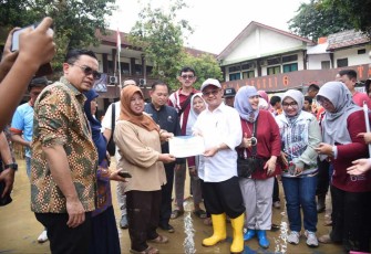 Mendikdasmen Abdul Mu'ti saat memberikan bantuan untuk sekolah terdampak banjir di Bekasi, Kamis (6/3)