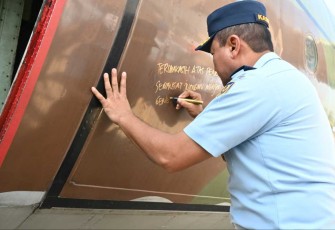 Kasau Marsekal TNI M Tonny Harjono saat menuliskan kenangan di body pesawat Hercules A-1303, di Bandung, Rabu (23/4)
