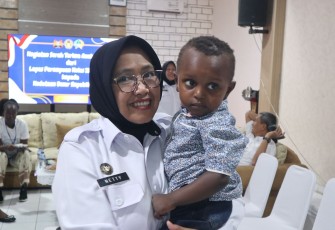 Kalapas Perempuan Jakarta Nety Saraswaty menggendong anak warga Kenya, Kamis (23/10)