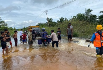 Polsek Singkil saat melakukan pengaturan lalu lintas di ruas jalan Singkil – Sebatang tepatnya Desa Pea Bumbung, Kecamatan Singkil, Kabupaten Aceh Singkil, yang putus akibat tergerus derasnya aliran air pascahujan lebat yang melanda wilayah tersebut, Minggu (23/11/2025)