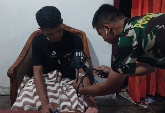 Tim kesehatan satgas TMMD Kodim 1310/Bitung saat melakukan pemeriksaan kesehatan terhadap salah satu personil satgas yang sedang sakit