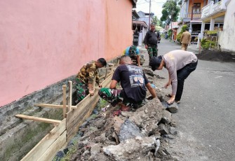 Satgas TMMD Kodim 1310/Bitung bersama warga saat memperbaiki saluran air yang melintas di pemukiman warga