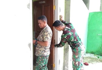 Personel Satgas TMMD Ke-123 Kodim 1310/Bitung saat melakukan pemasangan pintu ruang belajar