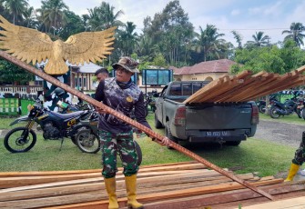 Satgas Pra TMMD ke-124 saat Bongkar Kayu Untuk Pembuatan Baliho