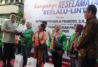 Anggota DPRD Jatim Cahyo Harjo Prakoso saat membagikan helm gratis ke perwakilan Ojol