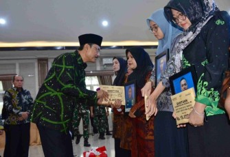 Mensos Saifullah Yusuf menyerahkan santunan duka ahli waris prajurit TNI AL korban longsor Cisarua di Jakarta, Selasa (10/2)