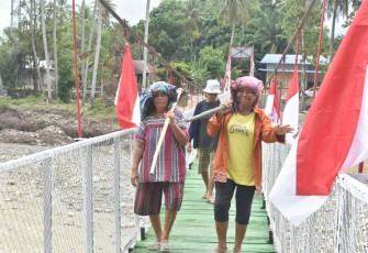 Warga desa Mudik saat melintasi di jembatan perintis Garuda, Senin (16/3)