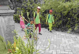 Anak-anak pulang sekolah melewati jalan paving