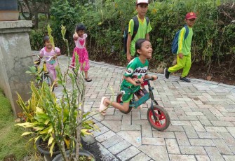 Anak-anak gembira bermain di jalan paving