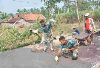Prada Aditya Rohman Rapikan Permukaan Rabat Beton TMMD