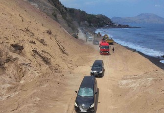 Kendaraan melintasi akses lalu lintas jalur Trans Flores yang sebelumnya tertutup material longsor akibat gempa M 7,7 Flores di Kabupaten Ende, Kamis (20/9)