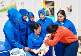 Ketua Daerah Jalasenastri Kodaeral IX, Ny Inca Hanarko pangku balita di posyandu Bobara