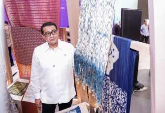 Menteri Ekonomi Kreatif/Kepala Badan Ekonomi Kreatif (Ekraf), Teuku Riefky Harsya meninjau koleksi kain tenun seusai membuka Glory Indonesia 2026 : Weaving Archipelago di Senayan City, Jakarta, Rabu (12/08/2026)
