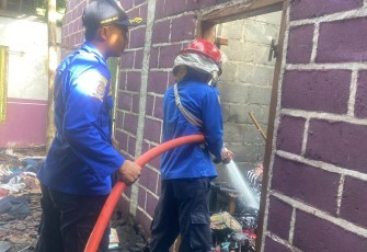 Petugas Damkar Karanganyar memadamkan api yang membakar rumah milik Ngatiyem di Dusun Tohkuning, RT 02/RW 14, Desa Karangpandan, Karanganyar, Jumat pagi (6/3/2026).