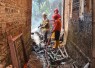 Petugas melakukan proses pendinginan di lokasi kebakaran rumah milik Erna (30), di Dusun Tirto RT 01 RW 12, Bolong, Karanganyar, Kamis pagi (9/7/2026)